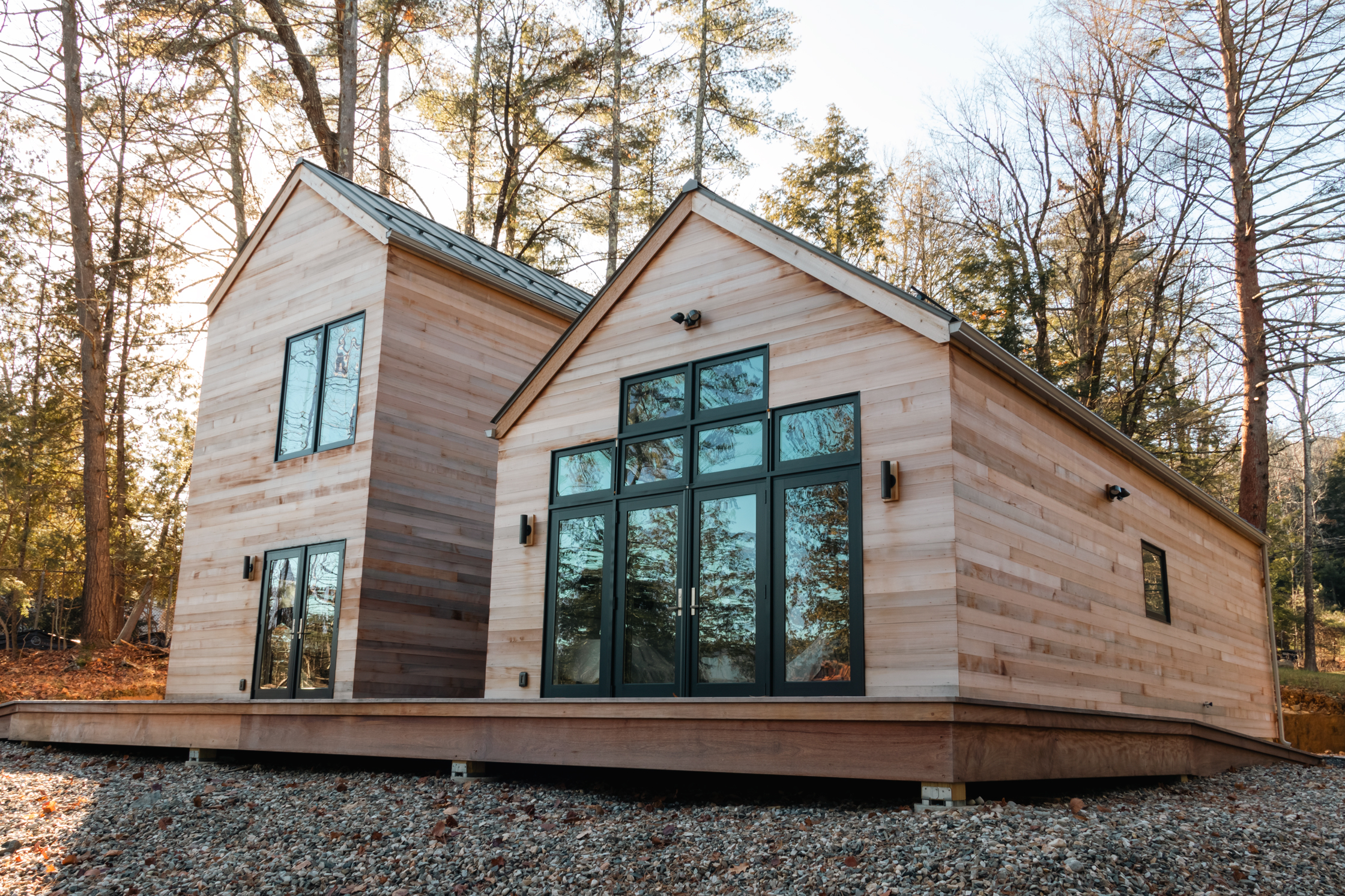 Tucked into the trees behind an overlooking Lake George Summer Home, this modern guest cottage retreat gives peaking Adirondack Views. 