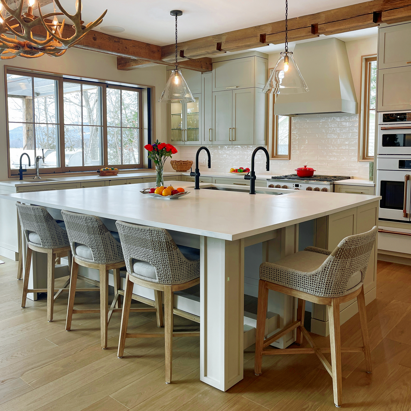 This spacious chef’s kitchen was designed to be multi-functional and accommodating to multiple uses. The warm white cabinets are complimented by white artisan subway tile backsplash and reclaimed hemlock beams that interlock across the ceiling. AJA worked with Zobel Kitchens to create functional cabinetry to utilize all the possible space in fun and unique ways.