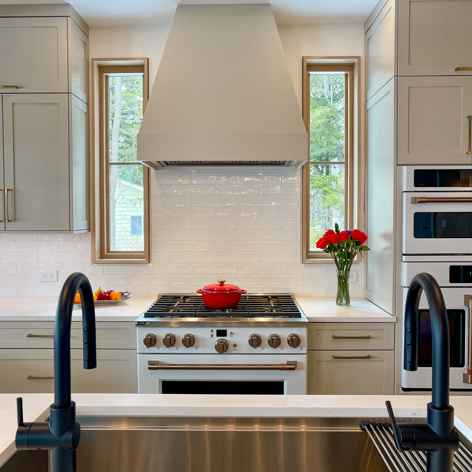 The cabinetry of the kitchen was meticulously desinged and placed around the ceiling beams, custom hood, and viewing windows that book end the range. 