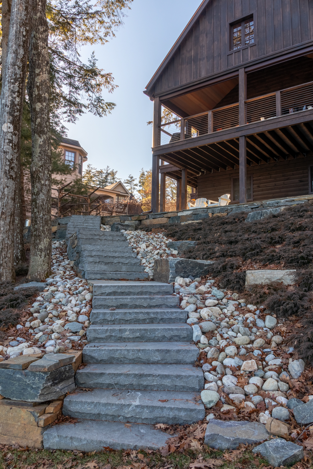 The outdoor deck directly connects the cabin's interiors to the newly constructed stone staircase to the water's edge. 