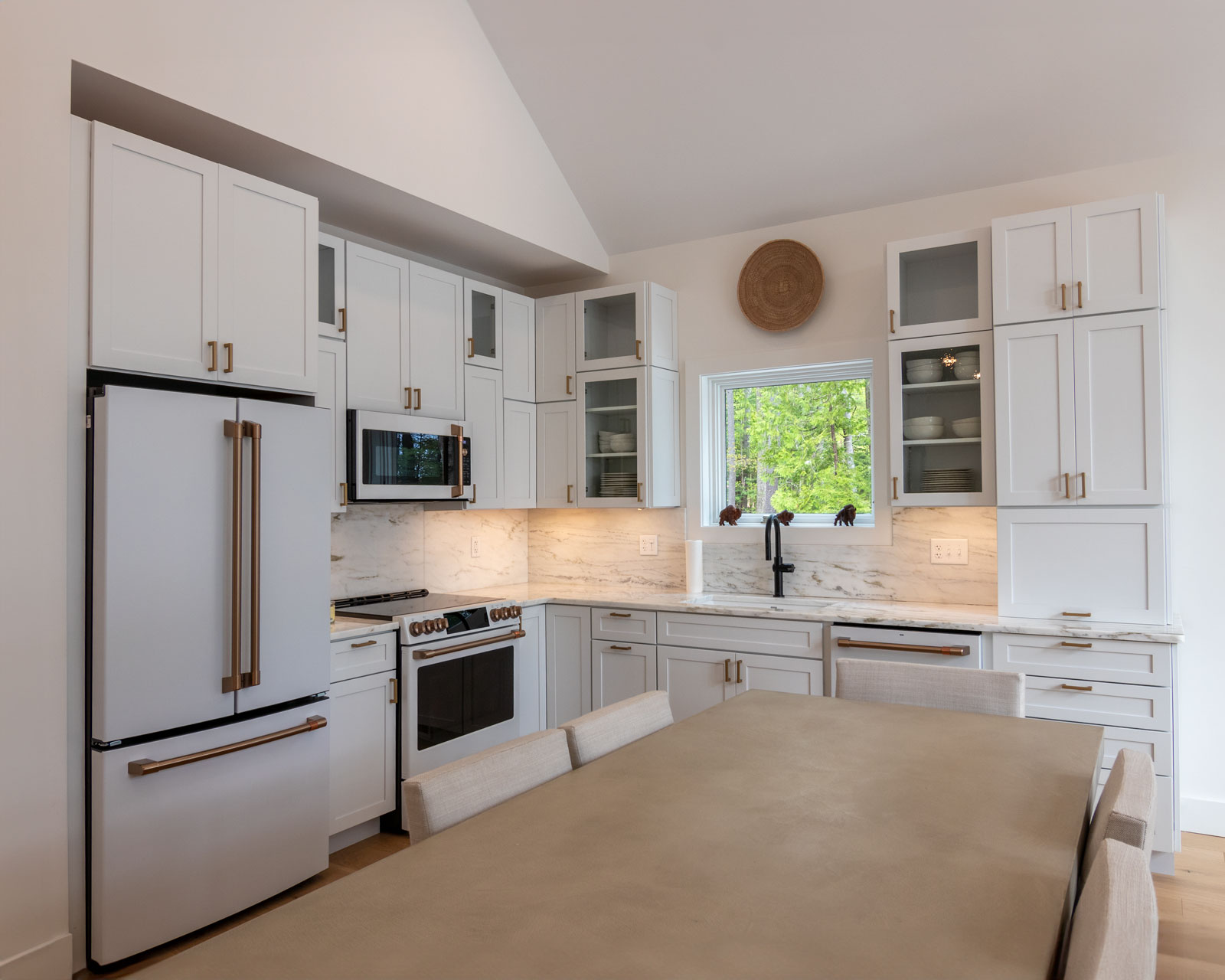 Rock View Kitchen The Rock View Cabin kitchen is adorned with an elegant white interior that was inspired by historic lakeside camps. The white with bronze hardware Cafe Appliances gives a classy and refined look.