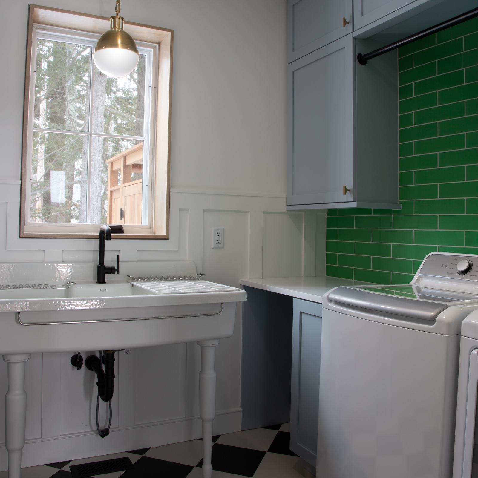 harpers-fin-laundry The Laundry Room is a fun take on a vintage farmhouse-style laundry room. Black and white checkered floor, vintage sink and Kelly green tile backsplash make this room pop. Peaking through the window you can spot the outdoor shower.